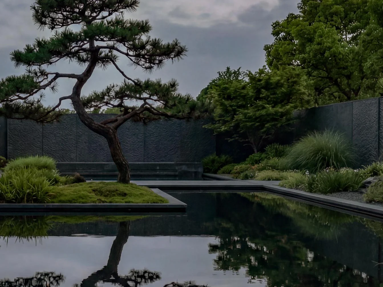 Aetas Taman Desa garden with a pine tree beside a reflecting pool