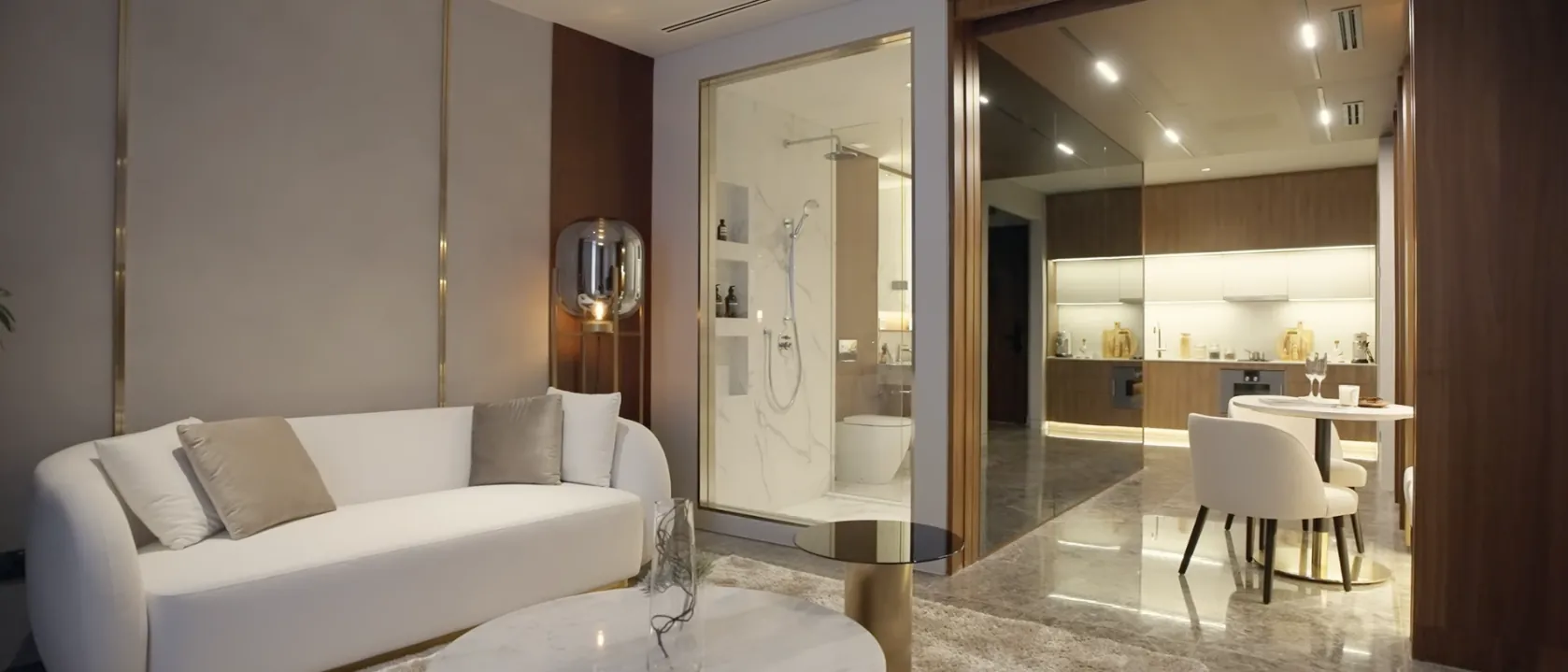 CloutHaus Residences show unit living room with marble floors and a glass-walled bathroom