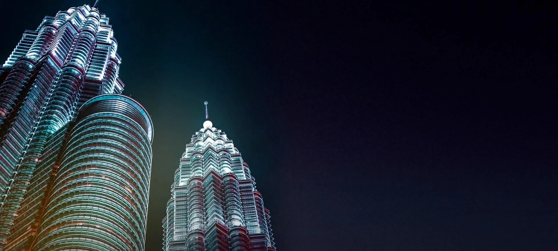 The Petronas Twin Towers lit up at night, 400 m from Divine KLCC