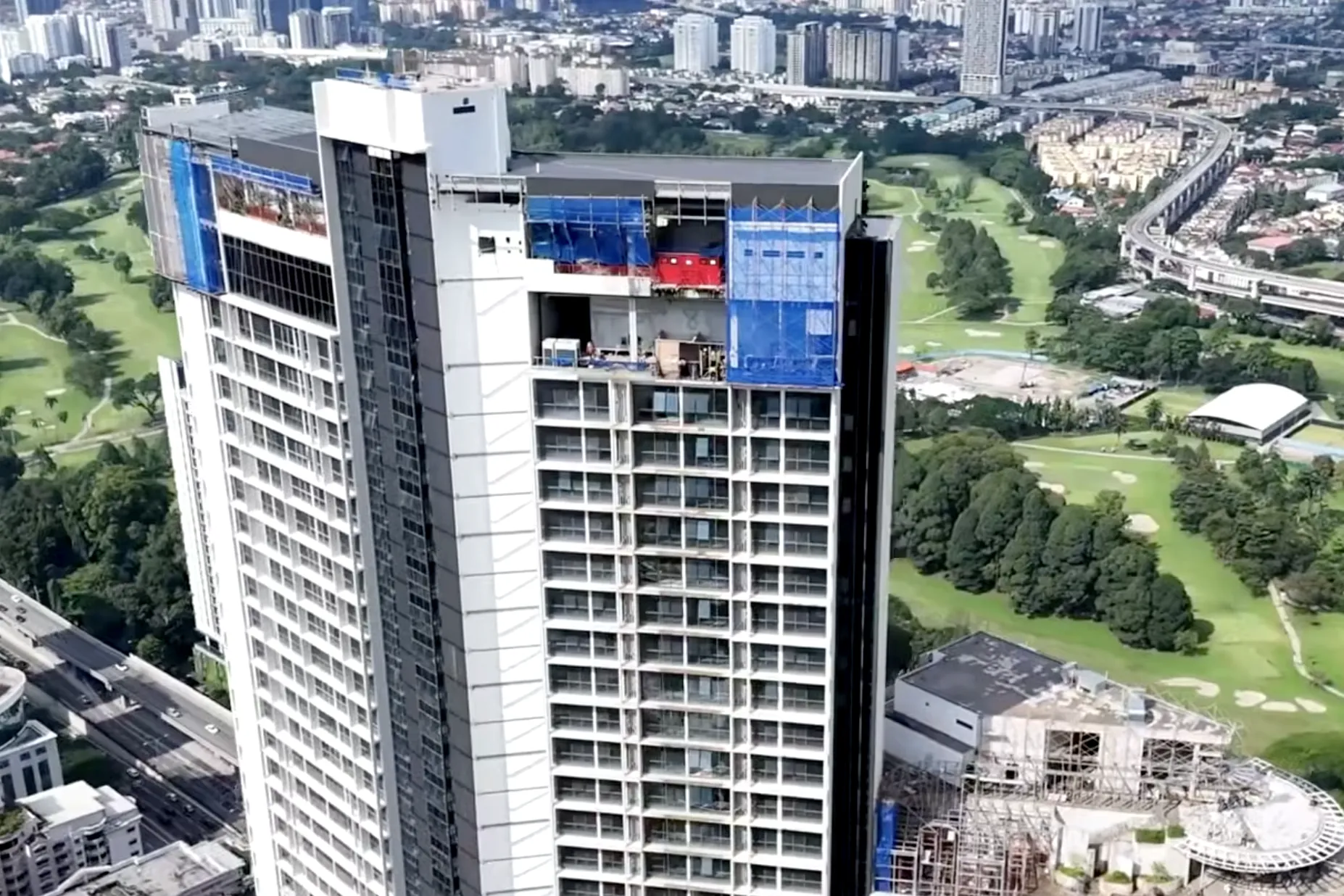 Golden Crown Residence tower nearly complete on Jalan Tun Razak, with a golf course beyond