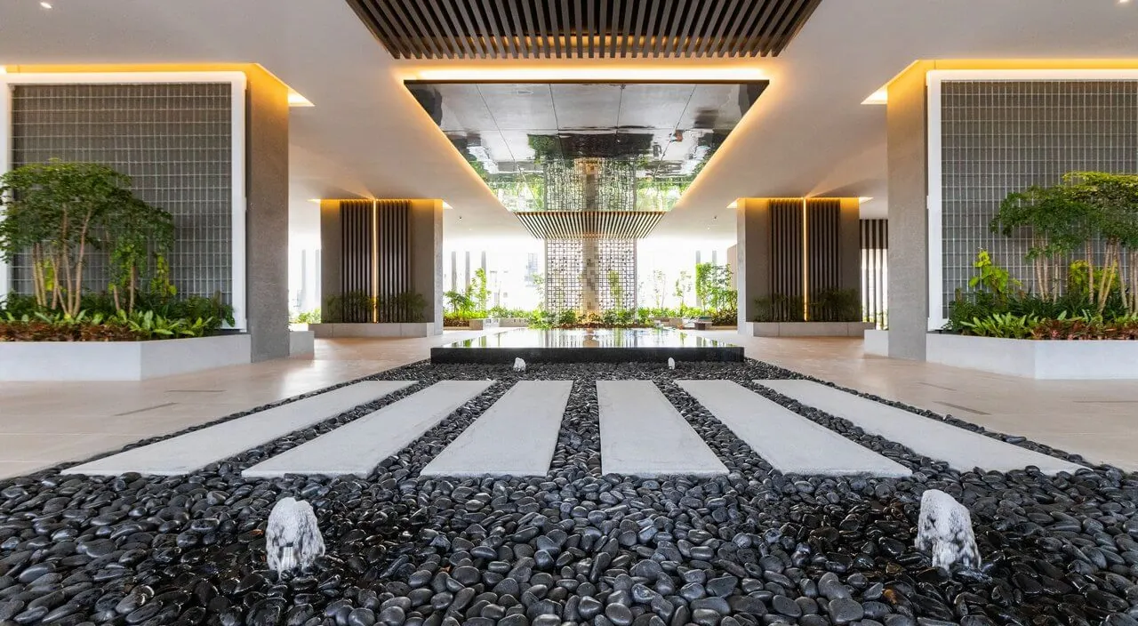 The grand lobby of Laurel Residence, with stepping stones over a pebble water feature