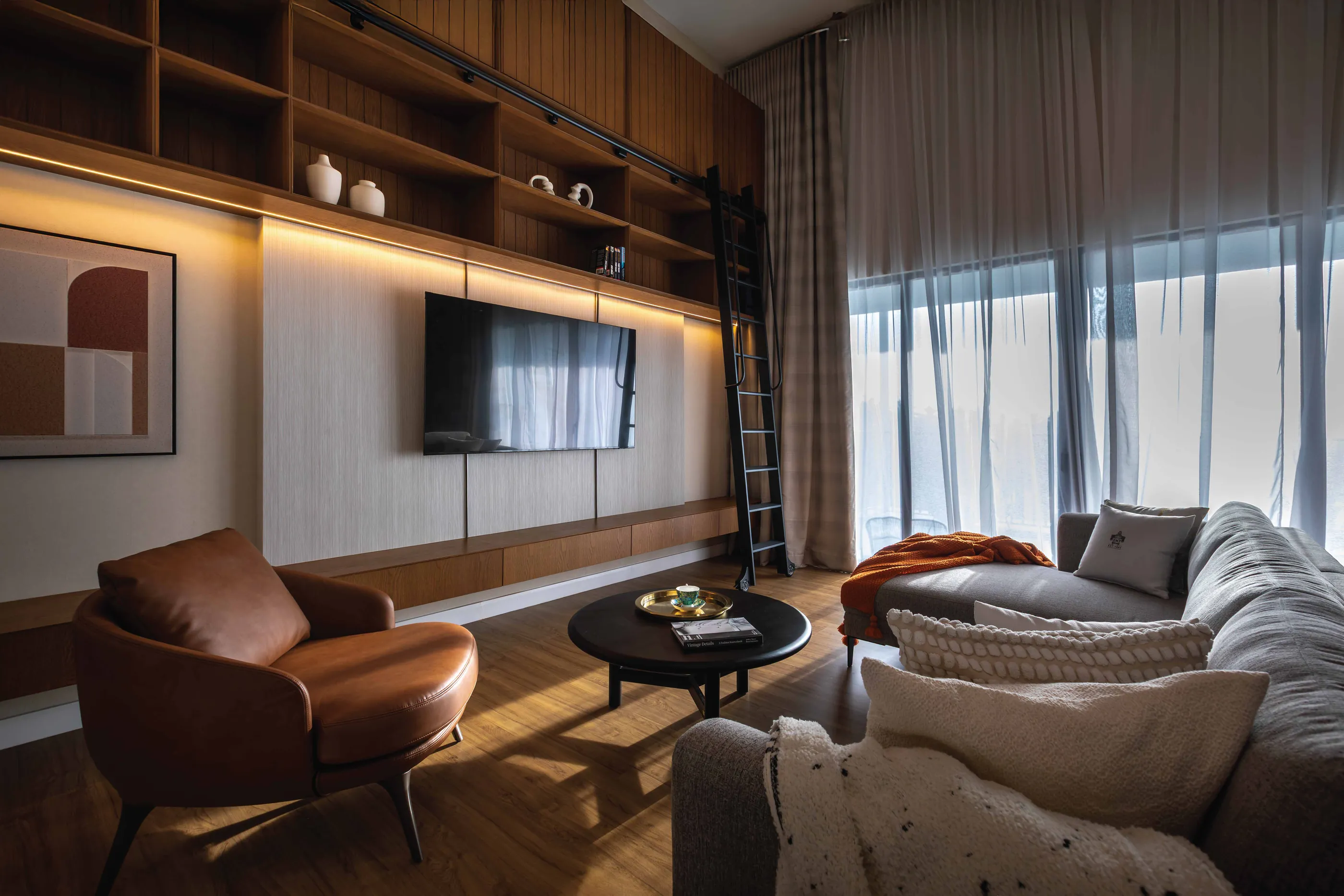 A family area with timber shelves and tall curtains at Seri Embun
